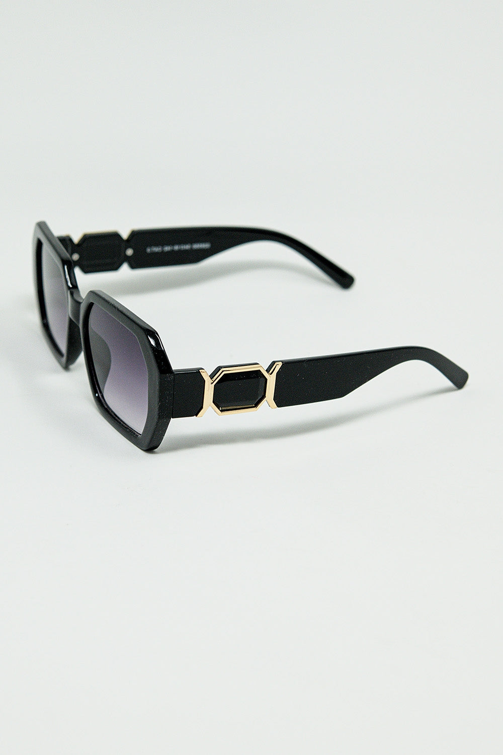 Lunettes de soleil noires en forme de losange et détails dorés