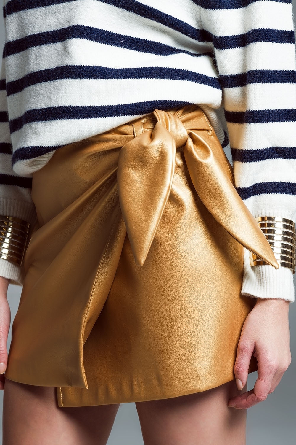 mini-jupe en faux cuir avec nœud sur le côté en or