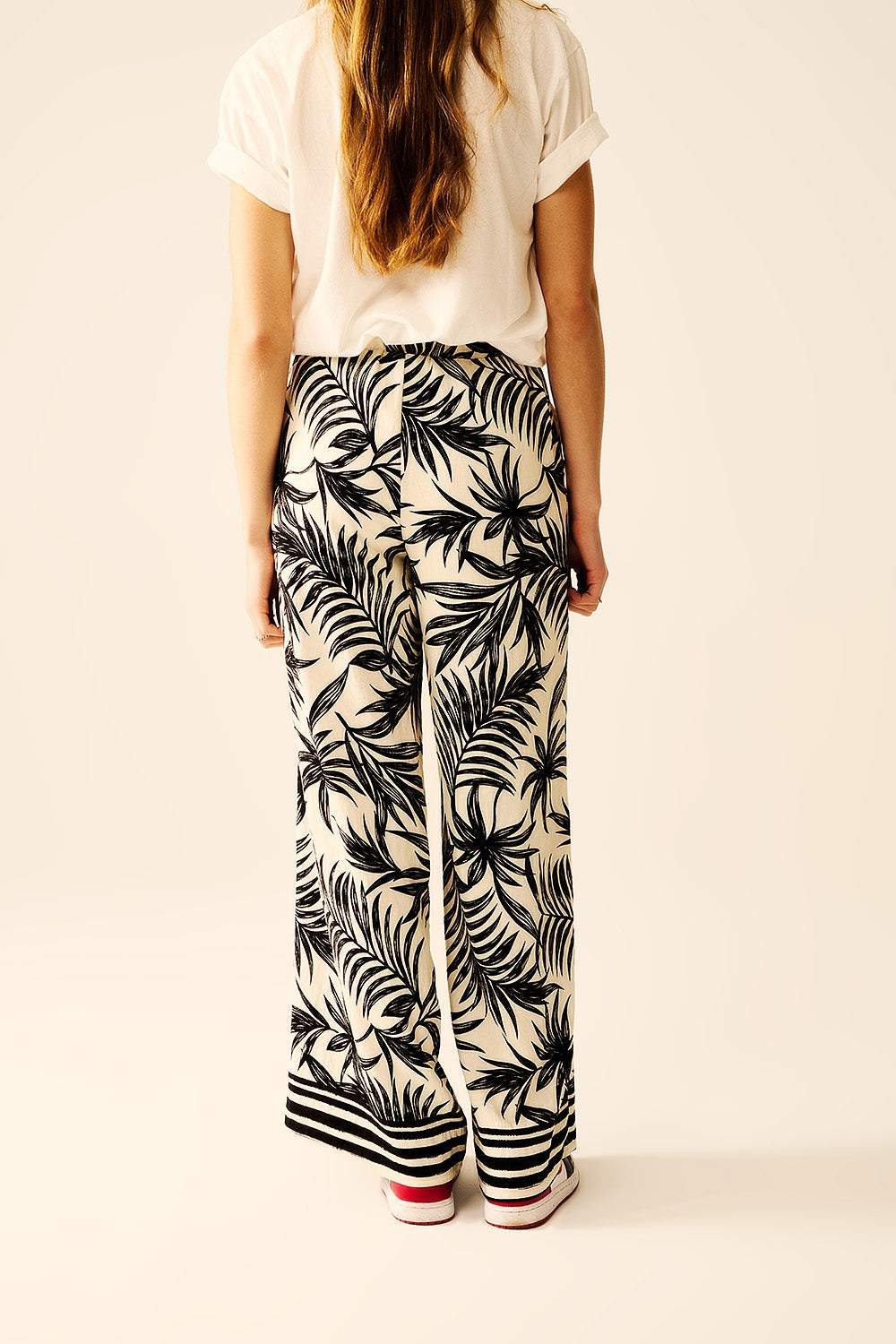 Pantalon à jambes larges en blanc avec détails floraux en noir