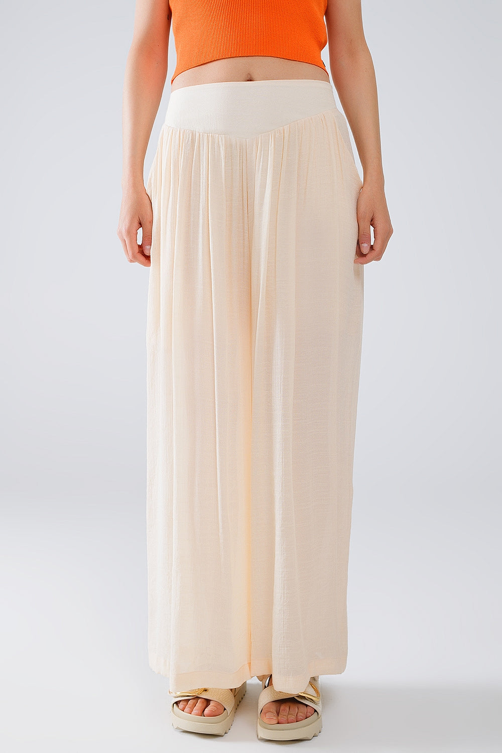 Pantalon de style palazzo beige avec poches latérales et bande de taille épaisse