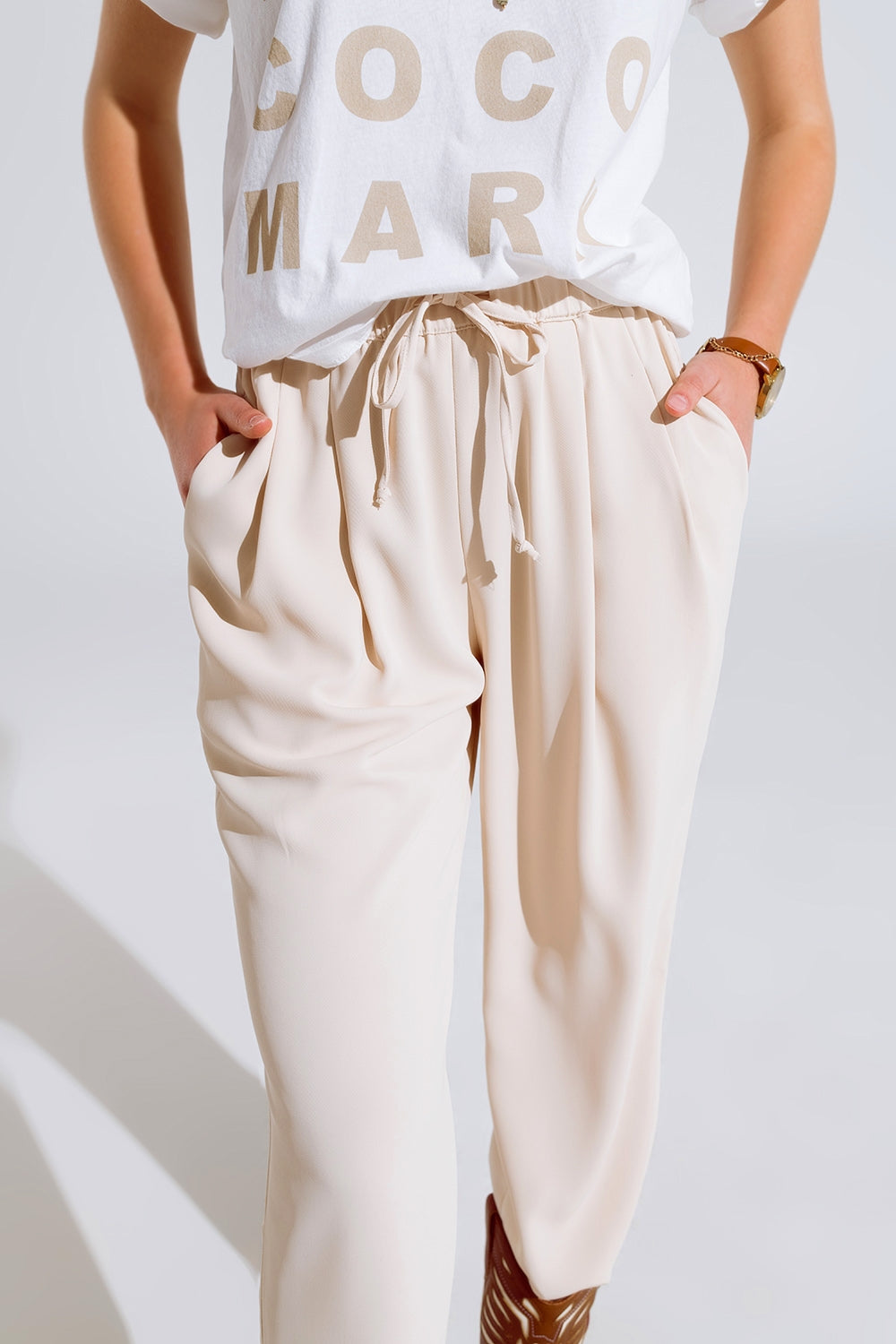 Pantalon en beige avec poches avant et fermeture par cordon de serrage