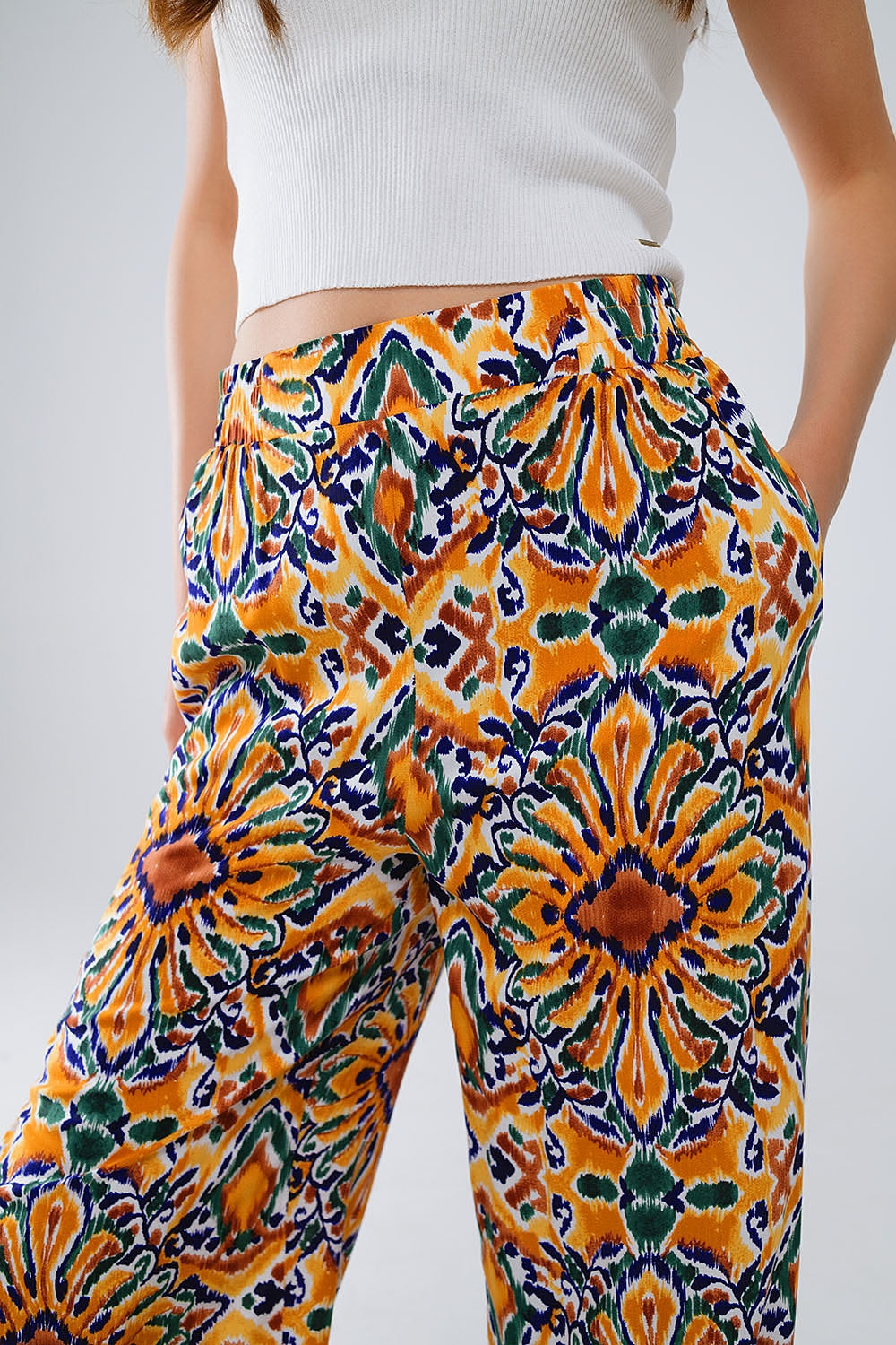 Pantalon multicouleure avec impression de fleurs en orange et bleu