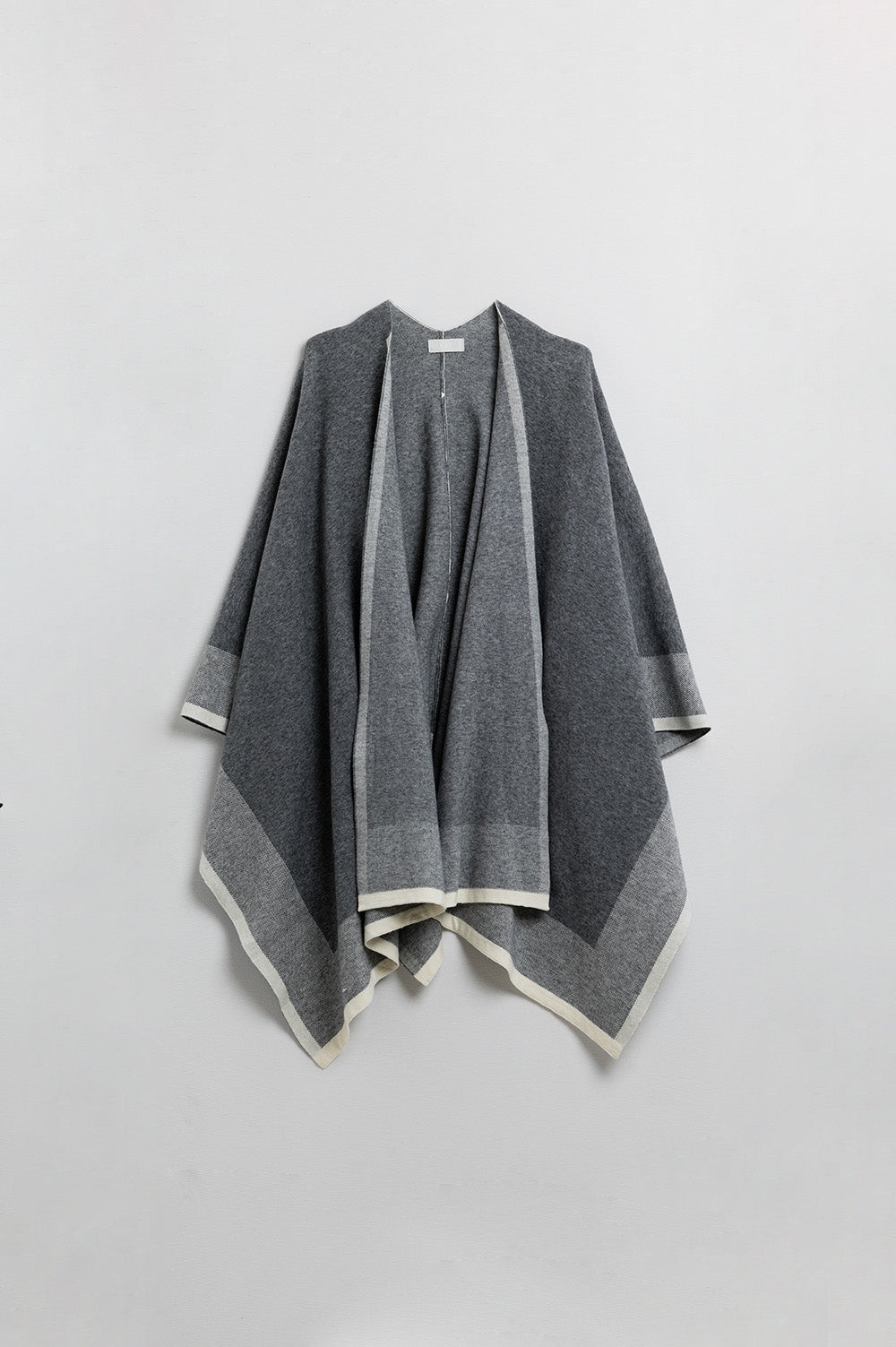 Poncho tricoté en gris avec bordures écrues