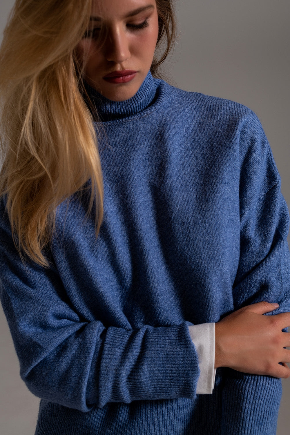 Pull à col roulé bleu dans un tissu tricoté doux