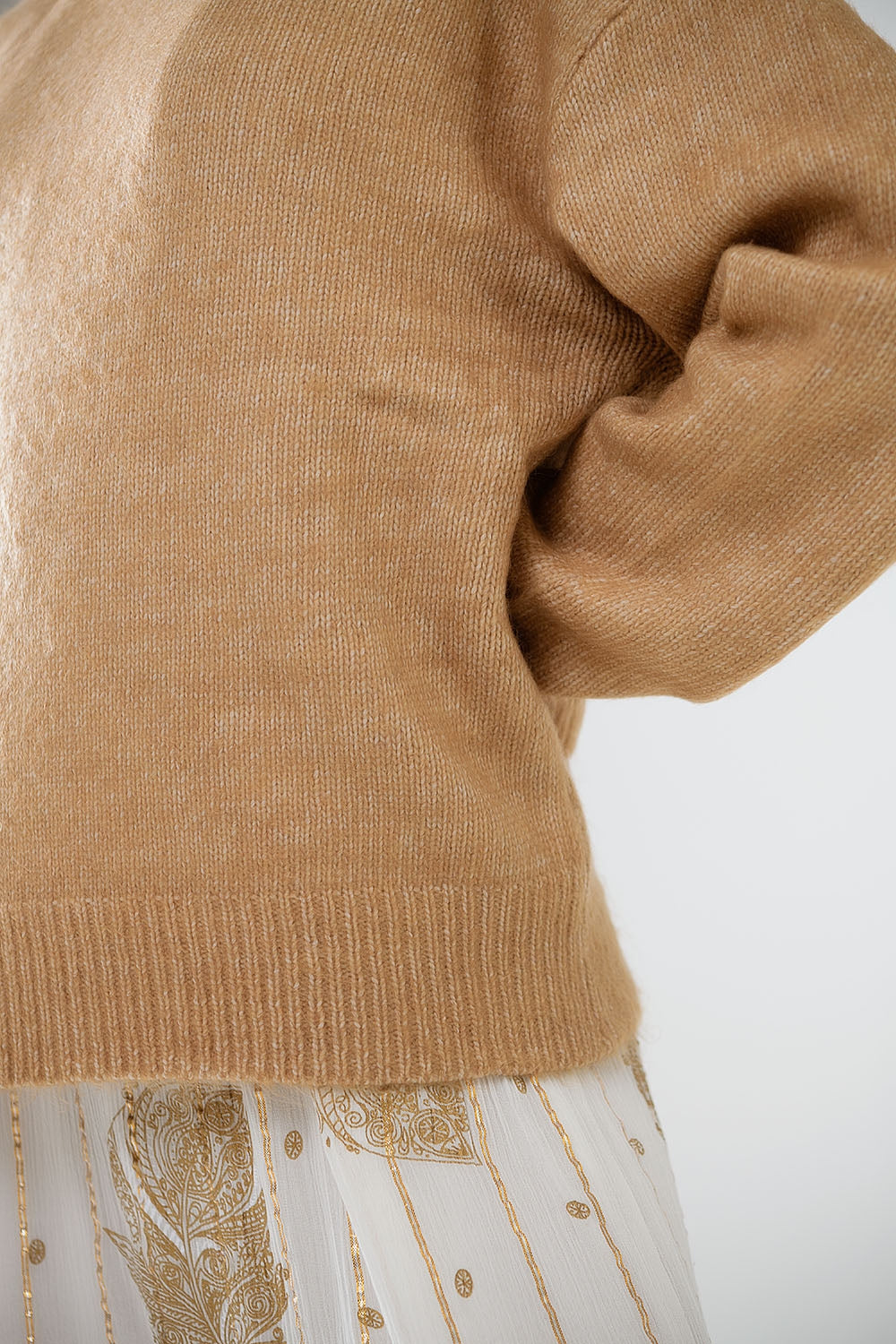 Pull beige à col roulé et manches tombantes