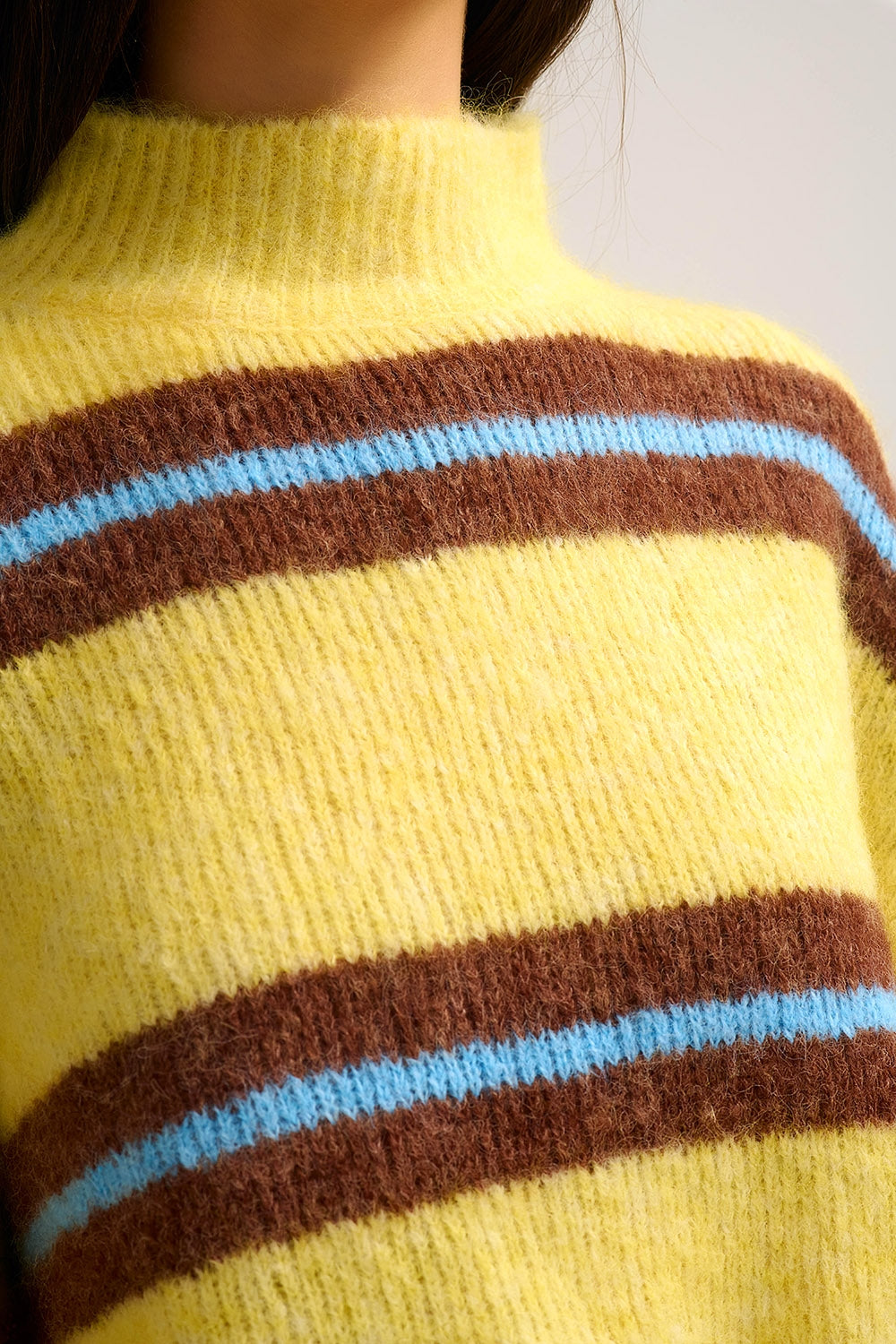 Pull jaune en tricot avec des rayures marron et bleues