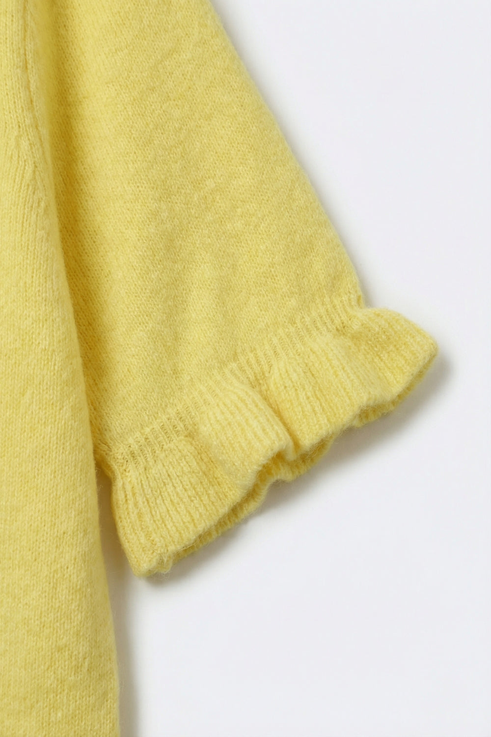 Pull jaune en tricot doux et moelleux avec des manches à volants
