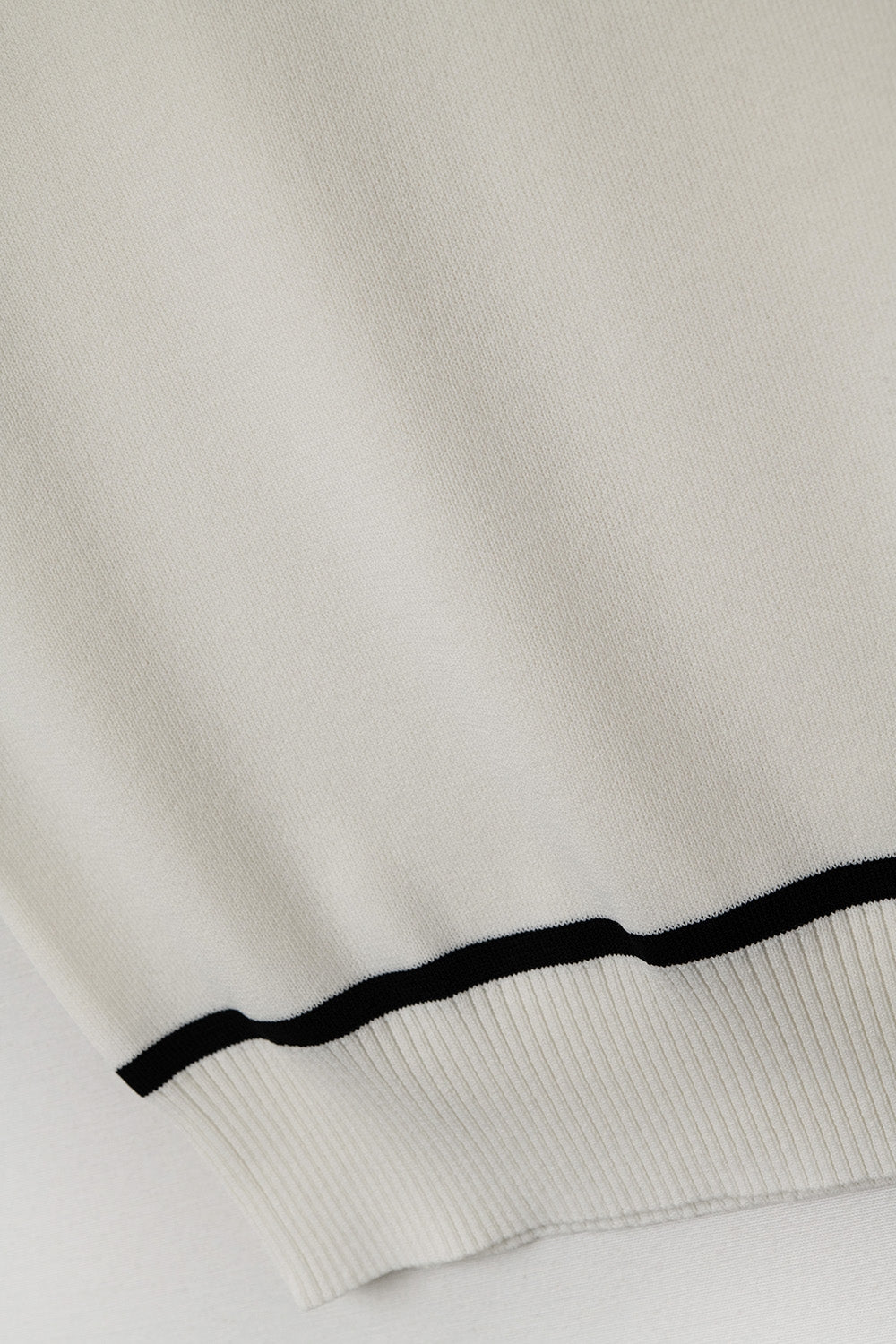 Pull sans manches blanc avec des lignes noires à l'extérieur