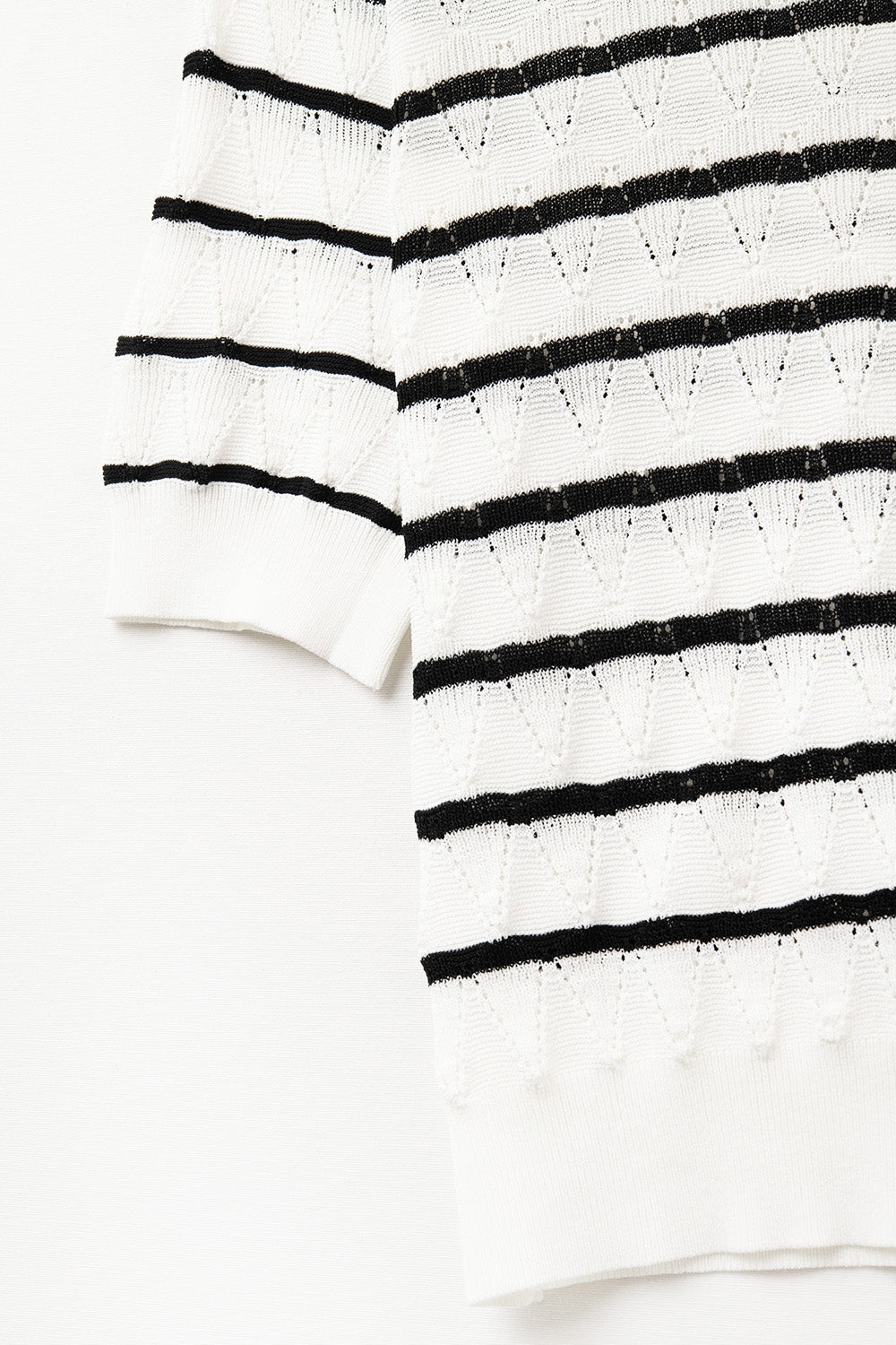 Top blanc en tricot ajouré avec manches courtes et rayures noires