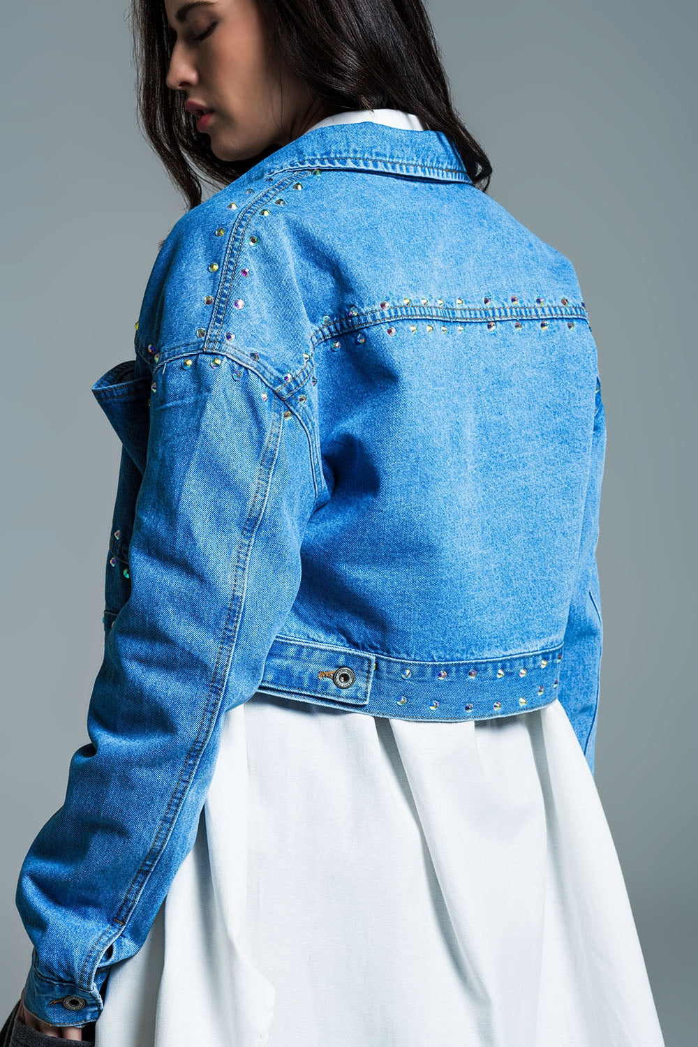 Veste croisée en denim bleu avec clous et poches sur la poitrine